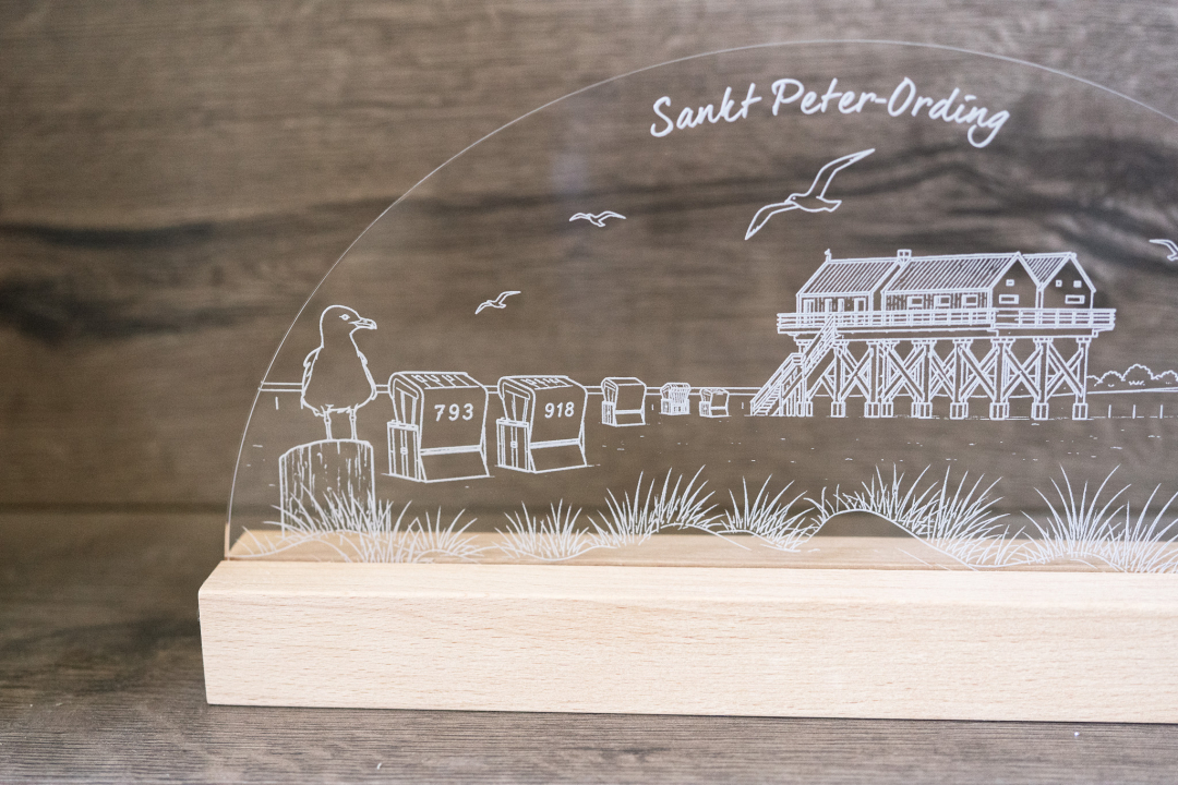 Preview: LED-Tischlampe mit graviertem Sankt-Peter-Ording-Motiv (Pfahlbau, Leuchtturm, Strandkörbe) auf Acrylglas und Holzsockel, warmweißes Licht