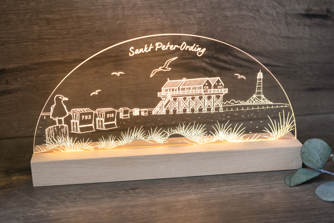 LED-Tischlampe mit graviertem Sankt-Peter-Ording-Motiv (Pfahlbau, Leuchtturm, Strandkörbe) auf Acrylglas und Holzsockel, warmweißes Licht