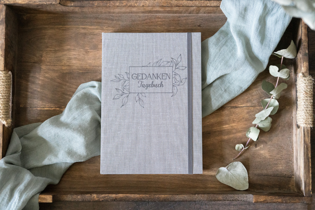 Graues Leinen-Notizbuch A5 mit floralem Motiv und personalisierbarem Text „Gedanken Tagebuch“, Verschlussband und Rahmen-Design