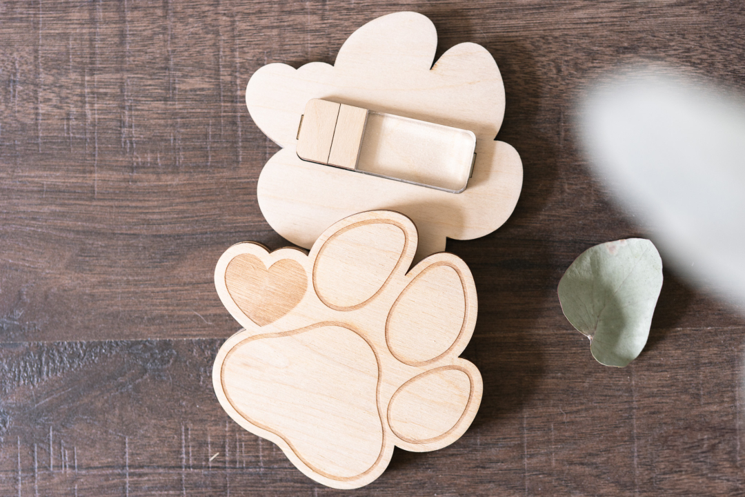 USB-Stick in Holzbox in Pfotenform, personalisierbar mit Namensgravur, auf Holztisch fotografiert